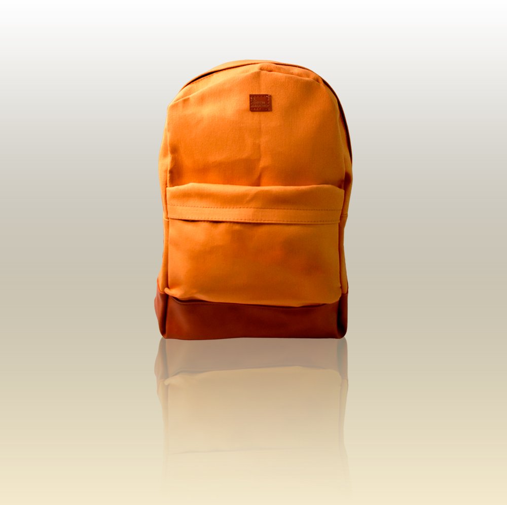 Mochila de Lona reforzada con espacio para notebook y bolsillo delantero. Diseño liso color naranja mango con detalles en eco-cuero cuero marrón-